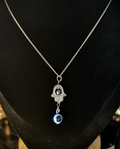 Hamsa hand and evil eye charm on 16 inch silver tone chain